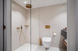 a bathroom with a toilet and a glass shower at Copenhagen Admiral Hotel in Copenhagen