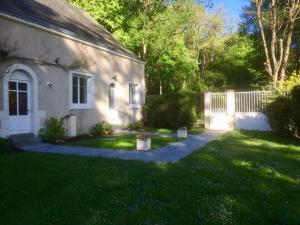 una casa blanca con una valla y un patio en Les Moulins de Requeugne, en Tauxigny