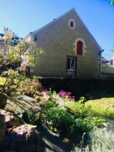 una casa con una ventana y flores delante de ella en Les Moulins de Requeugne, en Tauxigny