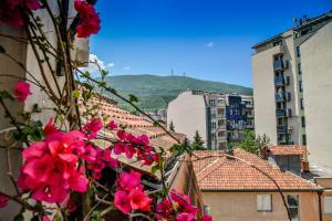 uma vista para uma cidade com flores e edifícios cor-de-rosa em Tomas Apartments em Skopje