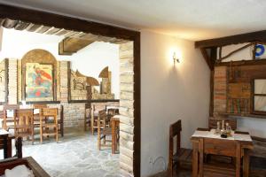 uma sala de jantar com mesas e cadeiras e uma parede de tijolos em Family Hotel Gery em Kranevo