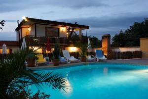 a villa with a swimming pool at night at Family Hotel Gery in Kranevo