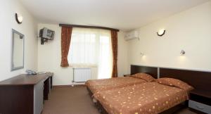 1 dormitorio con cama, escritorio y ventana en Family Hotel Gery en Kranevo