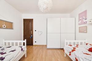 a white bedroom with two beds and a closet at Villa Amelie in Kaštelir +33 photos