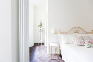 a white bedroom with a bed and a table at Alessia's Place in Como