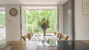 a dining room with a table with a vase of flowers at Glanafon Cottage in Bethesda