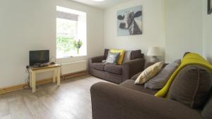 a living room with a couch and a tv at Glanafon Cottage in Bethesda