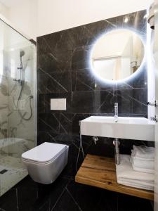 a bathroom with a sink and a toilet and a mirror at Hotel Florence in Marotta