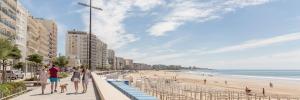 a group of people walking along a beach at Appartement 4 couchages, 100 mètres de la mer ! in Les Sables-dʼOlonne