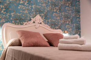 a bed with brown pillows and a floral wallpaper at Me&Sea B&B in San Nicola Arcella