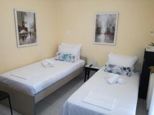 duas camas individuais num quarto com duas mesas em Apartment studio near Marousi station Athens em Atenas