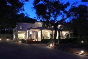 una casa bianca di notte con le luci sopra di Dimora Villa Serena Porto Selvaggio a Santa Caterina di Nardò