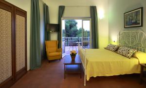 a bedroom with a bed and a chair and a window at Dimora Villa Serena Porto Selvaggio in Santa Caterina di Nardò