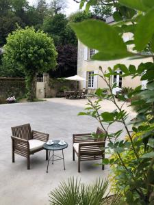 a patio with two chairs and a table and a building at Chambre Troglodytique Villa Marie Louise in Rochecorbon