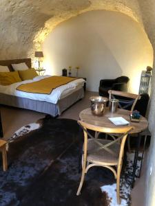 um quarto com uma cama e uma mesa e uma mesa sidx sidx sidx em Chambre Troglodytique Villa Marie Louise em Rochecorbon