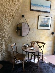 a table and chairs in a room with a mirror at Chambre Troglodytique Villa Marie Louise in Rochecorbon