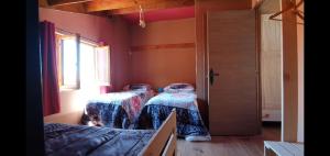 twee bedden in een kamer met een raam bij Casita Morada in Navalespino
