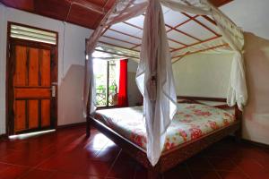 a bedroom with a bed with a canopy at Bagus Bay Homestay in Tuktuk Siadong