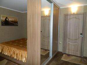 1 dormitorio con 1 cama y puerta de cristal en ул. Киевская Апартаменты, en Kremenchuk