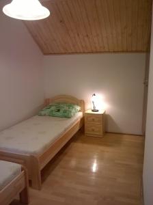 ein Schlafzimmer mit einem Bett und einer Lampe auf einem Nachttisch in der Unterkunft ZENITH APARTMAN in Gárdony