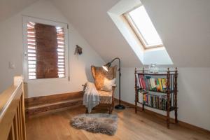 ein Dachzimmer mit einem Stuhl und einem Bücherregal in der Unterkunft Ferienhaus "Troadkammer" in der Südsteiermark in Oberhaag