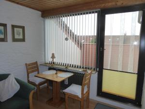 ein Esszimmer mit einem Tisch, Stühlen und einem Fenster in der Unterkunft Ferienwohnung Kullmann-Arendt in Isny im Allgäu
