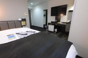a hotel room with a bed and a flat screen tv at APA Hotel Suzuka-Chuou in Suzuka
