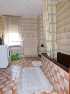 ein Bad mit einer Badewanne und einem Handtuch am Fenster in der Unterkunft Haus Videm in Videm pri Ptuju