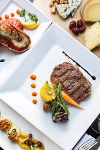 a plate of food with meat and vegetables on a table at Hotel Bellevue - Liburnia in Opatija