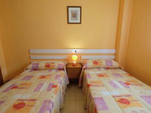 a room with two beds and a table with a lamp at Apartment Res Mediterraneo-6 by Interhome in Deltebre +7 photos