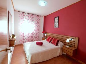 a bedroom with red walls and a bed with red pillows at Apartment Res Mediterraneo-6 by Interhome in Deltebre