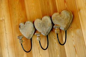 three heart hooks hanging on a wooden wall at Coup 2 Foudres in Saint-Jean-de-Blaignac