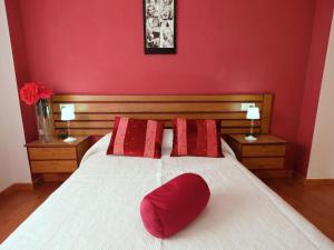 a red bedroom with a white bed with red pillows at Apartment Res Mediterraneo-6 by Interhome in Deltebre