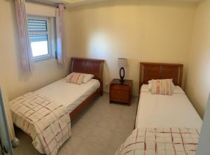 a bedroom with two beds and a window at Incredible Frontal Sea View - Praia da Galé in Albufeira