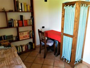 Locanda Agnella في بورتو مانتوفانو: غرفة مع طاولة حمراء ورف كتاب