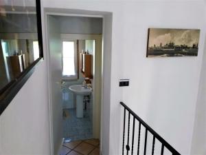 um corredor com uma casa de banho com um lavatório e um WC em Locanda Agnella em Porto Mantovano