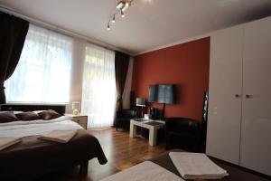 1 dormitorio con paredes rojas, 1 cama y escritorio en Rainbow Apartments 1 Premium, en Cracovia