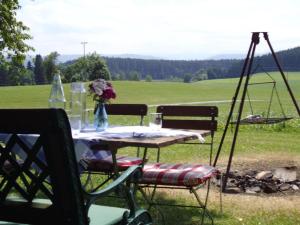 a picnic table with a vase of flowers on it at Rosenhof in Isny im Allgäu