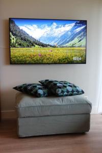 a flat screen tv hanging on a wall above a couch at Luxury Apartment Axams in Innsbruck