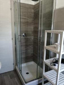 y baño con ducha y puerta de cristal. en Appartamento in centro paese, en Monterosi