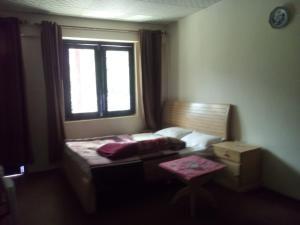 a small bedroom with a bed and a window at Abbott Hills Guest House in Kāgān