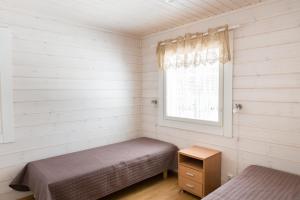 a bedroom with two beds and a window at Ruoke Holiday Village in Kesälahti