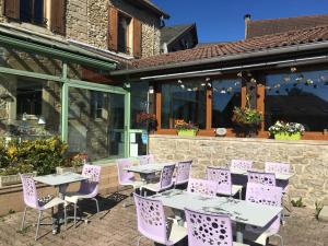 un patio avec des chaises et des tables violets dans un bâtiment dans l'établissement Auberge à la Vieille Cure, à Arandas