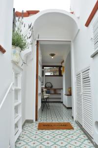 a hallway with an archway leading into a home with a table at Luna Caprese Guest House in Anacapri