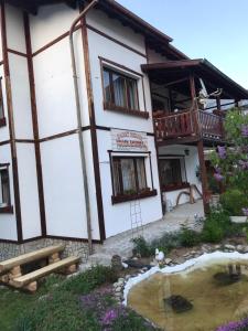a house with a pond in front of it at Mama Emiliya Guest House in Beli Iskar