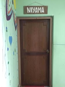 una porta di legno con un cartello sopra di Nepalaya Eco Hostel a Pokhara