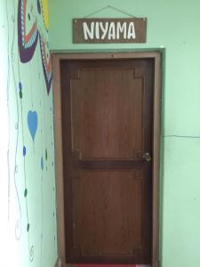 a wooden door with a sign above it at Nepalaya Eco Hostel in Pokhara