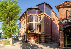 a building on a street next to a tree at Aura Aquarelle Hotel in Perm