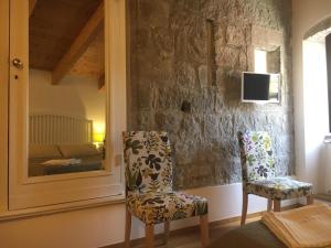 two chairs in a room with a stone wall at Al Libro Letto in Viterbo