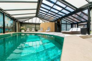 een zwembad in een huis met een glazen plafond bij Boutique Hotel Die Swaene in Brugge